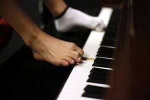 Безрукий китайский пианист играет ногами
